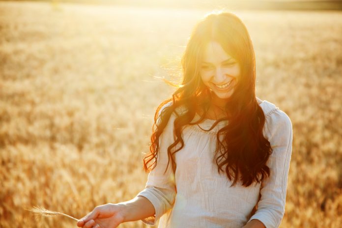 Žena se směje v poli pšenice